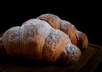 Two croissants on a dark background. French pastries.