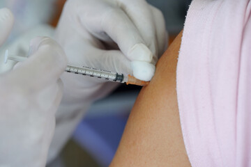 Doctor holding syringe and  make injection Covid-19 or coronavirus vaccine to patient.
