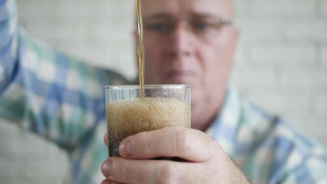 A Glass Filled with Cold, Sweet, Acidulated, and Refreshing Drink. Shooting with a Glass with a Fresh and Tasty Drink.