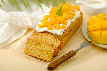 Homemade exotic mango pie with whipped cream, decorated with pieces of mango on beige background....