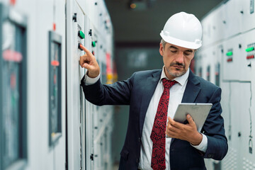 Portrait shot of senior engineer or management inspecting work in the electrical control room in...