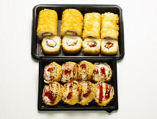 sushi set in an open black plastic bag with two chopsticks. White background. copy space.