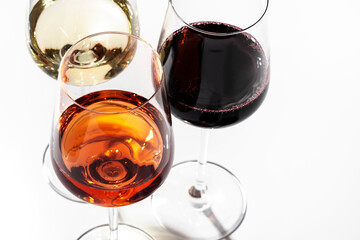 Red, rose and white wine in glasses on white background, top view. Wine bar, shop, winery, wine tasting concept. Hard light and harsh shadows
