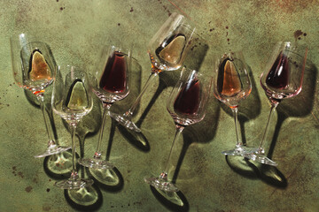 Red, rose and white wine in glasses on rusty green background, top view. Wine bar, shop, winery,...