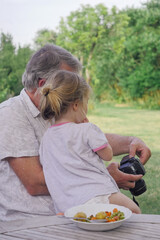 Petite fille sur les genoux de son grand-père vue de dos