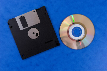 Floppy disk and Classic Compact Disc isolated on blue background