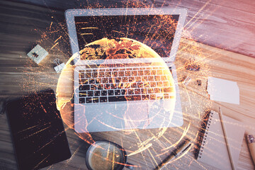 Social network hologram drawings over computer on the desktop background. Top view. Multi exposure....