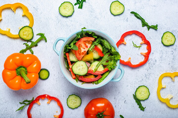 Cooking vegetable salad, vegetables in a blue bowl on a concrete background. Top view, flat lay