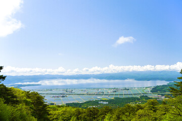 Fototapeta na wymiar 福島県・磐梯山から見下ろす田植え後の、猪苗代の町と猪苗代湖