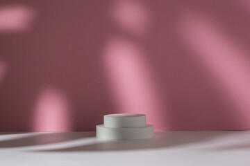 White podiums for presentation and shadow of monstera leaf on white pink background