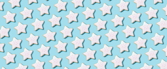 Background with cookies in the form of a star from above with icing on a blue background. Top view, flat lay. Banner