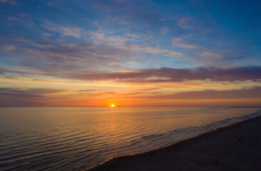 Aerial view of beautiful orange sunset sky over sea