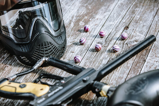 Close up of an equipment for action paintball game; protective mask, gun and ball bullets