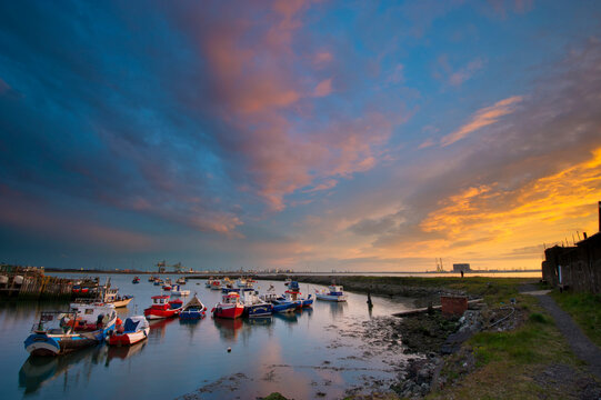 Small Fishing Boats in a Small Harbour with the Commercial Docks and a Dramatic Sunset