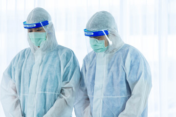Aging woman patient infected with CORONA VISRUS or COVID-19 and two medical staffs is standing beside patient bed in ICU and quarantine room at the hospital.