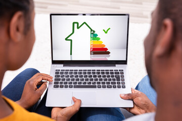 Couple Looking At House On Laptop
