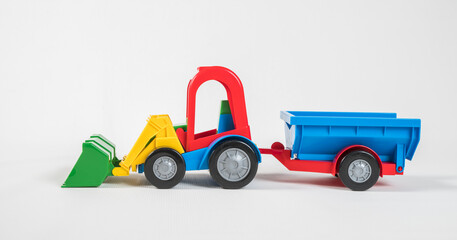 Plastic toy multicolored cars isolated on white background. Grader with a trailer.