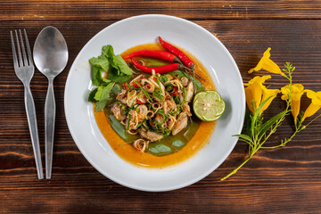 Fresh oysters are served in a white plate and topped with a spicy Thai-style sauce, also known as 
