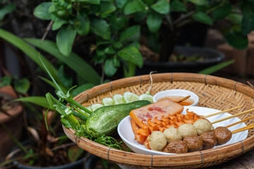 Skewers are arranged inside a white plate to prepare for the party. Fried food such as meatballs and hot dogs are skewed to make it easy to eat on a walk-in size, street food concept.