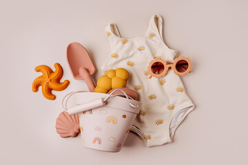 Top view of beach summer accessories for children. Fashion swimsuit,  sunglasses  and beach toys....