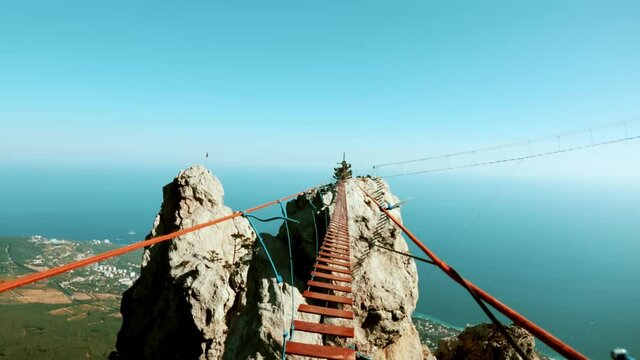 a hinged bridge high in the mountains of Crimea Ai-Petri. The sea in the background 