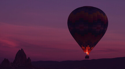 Fototapeta na wymiar Amazing heavenly background - huge colorful hot air balloon flies in glowing sunset sky