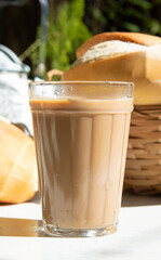 Breakfast in Brazil, bread, a pot of coffee in an American cup of milk and milk on an old white table, selective focus.