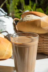 Breakfast in Brazil, bread, a pot of coffee in an American cup of milk and milk on an old white table, selective focus.