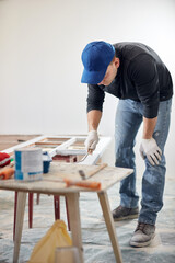 Young adult man painting on a DIY budget renovation of his new home apartment.