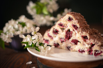 Homemade cake with cherries and cream on a wooden table. Dessert close-up. 