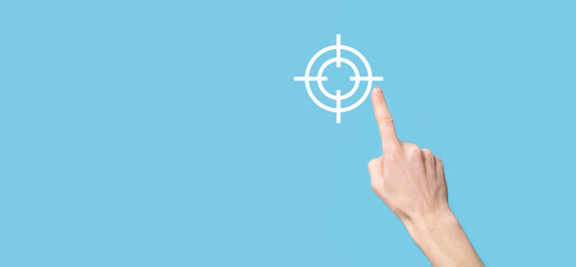 Targeting concept with hand holding target icon dartboard sketch on chalkboard. Objective target and investment goal concept.