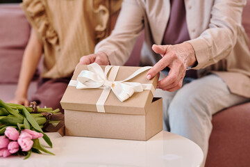 Hand of matue woman opening giftbox with birthday present