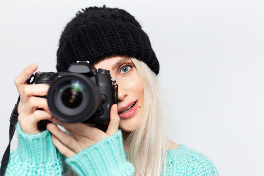 Portrait of blonde girl, photographer taking photo on DSLR camera, on white background.