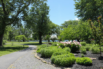 Winding path through Vitale Park on a sunny summer morning. Conesus lake in the background.