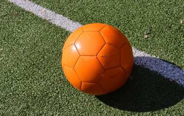 orange soccer ball on grass