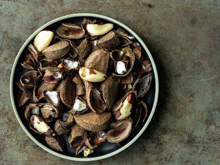 Brazil nuts on a dark plate with shell, husk, hull.