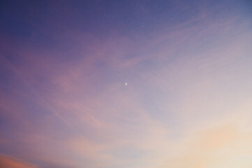 The waxing moon in a pink sky after sunset