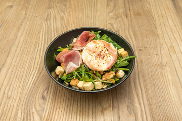 Goat cheese salad with arugula, croutons, walnuts, Iberian ham