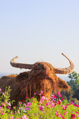 An animal shaped straw puppet is installed inside the flower garden to allow visitors to visit the...