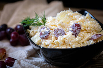 Grated cheese salad with garlic, pineapple and red grapes. 