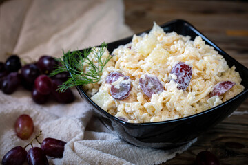 Grated cheese salad with garlic, pineapple and red grapes. 