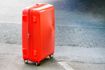 suitcase on castors costs on the street. case, trunk, bag, valise, portmanteau. Concept moving, travel, trip, flight. Concept Summer rest, holidays.