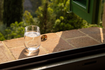Glass of water for the refreshment on the windowsill on a hot summer day in Italy. Toscana, Italia