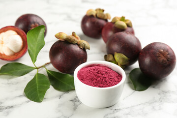 Purple mangosteen powder and fruits on white marble table