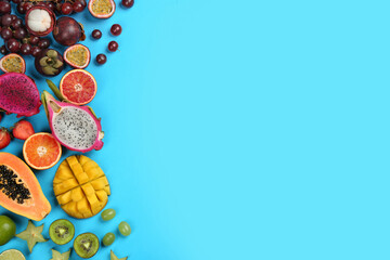 Many different delicious exotic fruits on light blue background, flat lay. Space for text