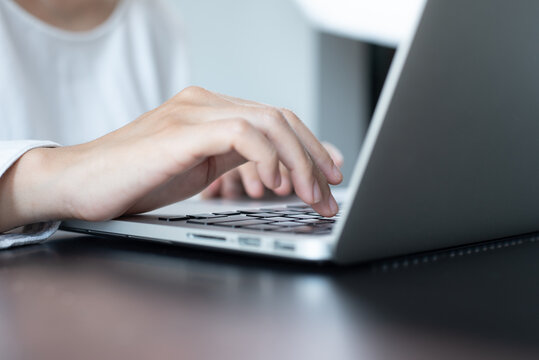 Close up image of woman hands typing, working on laptop computer keyboard on office table