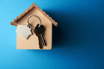 High angle view of keyring with a small house on colored background