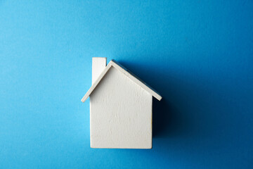 Fototapeta na wymiar Simply minimal design with miniature toy house isolated on blue background