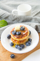 A healthy breakfast of pancakes, berries, butter, and honey. Creative atmospheric decoration