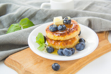 A healthy breakfast of pancakes, berries, butter, and honey. Creative atmospheric decoration